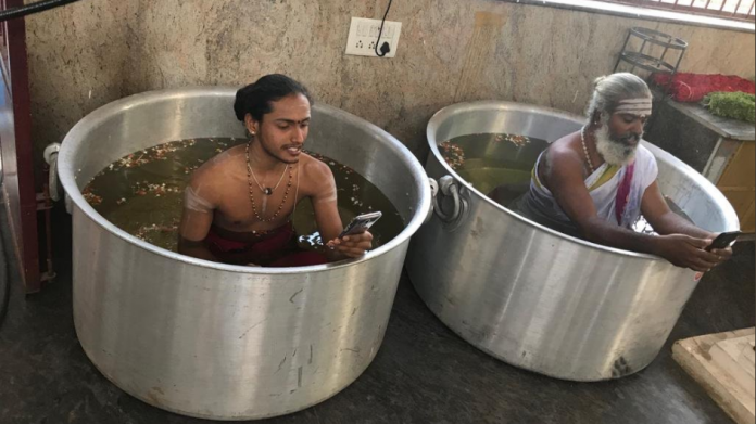 Social Media Lashes Out at Priests Sitting In Water-Filled Vessels And Checking Phones While Praying To Rain Gods